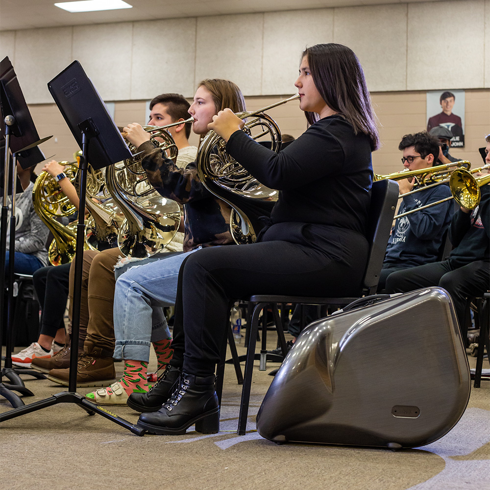 french horn player in band room